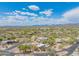 Scenic aerial view highlights a desert home with a pool, lush desert landscaping, and a terracotta tile roof at 4706 E Rancho Caliente Dr, Cave Creek, AZ 85331