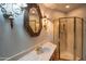 Stylish bathroom featuring a unique mirror, sconces, and a modern glass-enclosed shower at 4706 E Rancho Caliente Dr, Cave Creek, AZ 85331