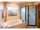 Bathroom featuring a luxurious soaking tub next to a glass enclosed shower and a view of the garden at 4706 E Rancho Caliente Dr, Cave Creek, AZ 85331
