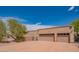 Spacious three-car garage exterior, complemented by desert landscaping and a wide driveway at 4706 E Rancho Caliente Dr, Cave Creek, AZ 85331