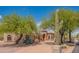 Inviting single-story home highlighting desert landscaping with mature trees and well-maintained surroundings at 4706 E Rancho Caliente Dr, Cave Creek, AZ 85331