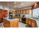 Traditional-style kitchen boasts wooden cabinets, central island cooktop and modern appliances at 4706 E Rancho Caliente Dr, Cave Creek, AZ 85331
