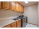 Well-lit laundry room with wooden cabinets and modern washer and dryer units at 4706 E Rancho Caliente Dr, Cave Creek, AZ 85331