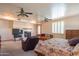 Comfortable main bedroom boasting a cozy fireplace, tv, seating area, and ceiling fans at 4706 E Rancho Caliente Dr, Cave Creek, AZ 85331