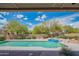Backyard view of a swimming pool and spa with desert landscaping under a bright blue sky at 4706 E Rancho Caliente Dr, Cave Creek, AZ 85331