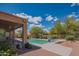 Back patio view of a backyard pool and spa with desert landscaping and clear blue sky at 4706 E Rancho Caliente Dr, Cave Creek, AZ 85331