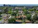 Scenic aerial view of a residential neighborhood with lush trees, houses, and city skyline in the distance at 512 W Roma Ave, Phoenix, AZ 85013