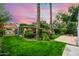 Spacious backyard with manicured lawn, mature trees, flowering bushes, and patio at 512 W Roma Ave, Phoenix, AZ 85013