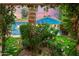 A backyard with lush gardens and trees showcases a charming blue home with a garage at 512 W Roma Ave, Phoenix, AZ 85013