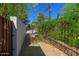 Fenced backyard with mature trees, a basketball hoop, and a gate, providing privacy and recreation at 512 W Roma Ave, Phoenix, AZ 85013