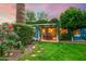 Serene backyard with covered patio, outdoor dining set, and lush greenery for relaxing and entertaining at 512 W Roma Ave, Phoenix, AZ 85013