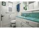 Charming bathroom with turquoise accents, white beadboard, and classic fixtures at 512 W Roma Ave, Phoenix, AZ 85013