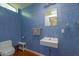 Stylish blue-tiled bathroom featuring a modern sink, toilet, and a window providing natural light at 512 W Roma Ave, Phoenix, AZ 85013