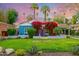 Inviting blue home featuring lush landscaping and bougainvillea around the front door, set against a stunning sky at 512 W Roma Ave, Phoenix, AZ 85013