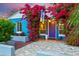 Inviting front porch adorned with bougainvillea, purple door, and decorative accents adding curb appeal at 512 W Roma Ave, Phoenix, AZ 85013