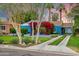 Charming blue house with well-manicured front yard, colorful bougainvillea and driveway leading to carport at 512 W Roma Ave, Phoenix, AZ 85013