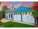 The blue garage features two white doors, beautiful plants, and outdoor lighting at 512 W Roma Ave, Phoenix, AZ 85013