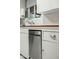 Vintage kitchen with white cabinetry, subway tile backsplash, stainless steel dishwasher and brown trim at 512 W Roma Ave, Phoenix, AZ 85013