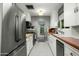 Well-lit kitchen with stainless steel appliances, white cabinetry, and tile flooring at 512 W Roma Ave, Phoenix, AZ 85013