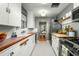 Charming kitchen with white cabinetry, tile backsplash, modern appliances, and views into the dining area at 512 W Roma Ave, Phoenix, AZ 85013