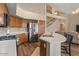 Bright kitchen with stainless steel appliances, wooden cabinets, and staircase in the background at 5330 W Morgan Pl, Chandler, AZ 85226