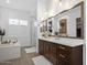 Bright bathroom showcasing a double sink vanity, soaking tub, and glass-enclosed shower at 5457 S Benton --, Mesa, AZ 85212