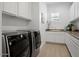 Well-equipped laundry room with modern appliances, white cabinets, and a utility sink at 5457 S Benton --, Mesa, AZ 85212