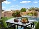 Cozy outdoor dining area with a view of the pool and lush landscaping in the backyard at 5457 S Benton --, Mesa, AZ 85212
