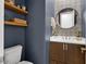 Stylish powder room featuring a floating shelf, decorative mirror, and modern fixtures at 5457 S Benton --, Mesa, AZ 85212