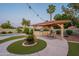 Outdoor gazebo with grill and dining area, pool and artificial turf surrounded by patio lights and desert landscaping at 5831 W Saragosa St, Chandler, AZ 85226