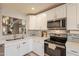 Modern kitchen boasts white cabinets, stainless steel appliances, and mosaic backsplash at 5831 W Saragosa St, Chandler, AZ 85226