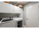 The laundry room features modern washer and dryer with built-in white cabinets for ample storage space at 5831 W Saragosa St, Chandler, AZ 85226