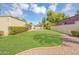 Serene backyard with lush lawn, mature trees, and a glimpse of the inviting pool at 6011 N 2Nd St, Phoenix, AZ 85012