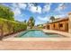 Refreshing backyard pool surrounded by lush landscaping, patio, and clear blue sky at 6011 N 2Nd St, Phoenix, AZ 85012