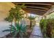 Inviting entryway featuring lush landscaping, a brick path, and a covered porch with exposed wood beams at 6011 N 2Nd St, Phoenix, AZ 85012