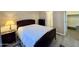 Bedroom featuring a dark wood bed frame, neutral walls and trim, with an ensuite bathroom and walk-in closet at 650 N Hawes Rd # 2827, Mesa, AZ 85207