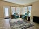 Comfortable living room featuring tile flooring, two plush chairs, and a wall of windows at 650 N Hawes Rd # 2827, Mesa, AZ 85207