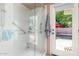 Bathroom shower and door to the backyard oasis, featuring a pool and comfortable seating at 6533 E Kelton Ln, Scottsdale, AZ 85254