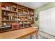 Comfortable home office with custom wood shelving, desk, chair and ceiling fan at 6533 E Kelton Ln, Scottsdale, AZ 85254