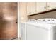 Bright laundry room with washer, dryer, white cabinets, and access to exterior perfect for everyday tasks at 6533 E Kelton Ln, Scottsdale, AZ 85254