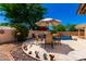 Backyard patio featuring an outdoor dining set, desert decor, and a rock-lined pool, creating a tranquil outdoor setting at 6533 E Kelton Ln, Scottsdale, AZ 85254
