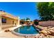 Inviting backyard pool area with rock accents, covered patio, and ample space for outdoor relaxation and entertaining at 6533 E Kelton Ln, Scottsdale, AZ 85254
