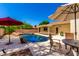 Beautiful backyard pool with rock accents, shaded by an umbrella, perfect for relaxation and outdoor entertaining at 6533 E Kelton Ln, Scottsdale, AZ 85254
