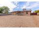 Wide view of the home's backyard, featuring a covered patio and ample space for landscaping at 655 E Hondo Ave, Apache Junction, AZ 85119