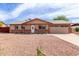 Inviting single-story home with a gravel yard and a well-lit entrance, complemented by an attached two-car garage at 655 E Hondo Ave, Apache Junction, AZ 85119