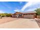 Well-maintained single-story house with a spacious driveway leading to an attached garage, complemented by a gravel yard at 655 E Hondo Ave, Apache Junction, AZ 85119