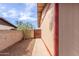 Side yard of home features gravel, block wall, and wooden gate access at 655 E Hondo Ave, Apache Junction, AZ 85119