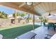 Lush backyard showcasing a covered patio, a sparkling pool, well-manicured turf, and desert landscaping at 6938 W Wescott Dr, Glendale, AZ 85308