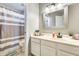 Well-lit bathroom with a vanity, mirror, and a shower with a striped curtain at 6938 W Wescott Dr, Glendale, AZ 85308
