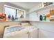 Bright laundry room with white washer and dryer, and storage shelving at 6938 W Wescott Dr, Glendale, AZ 85308